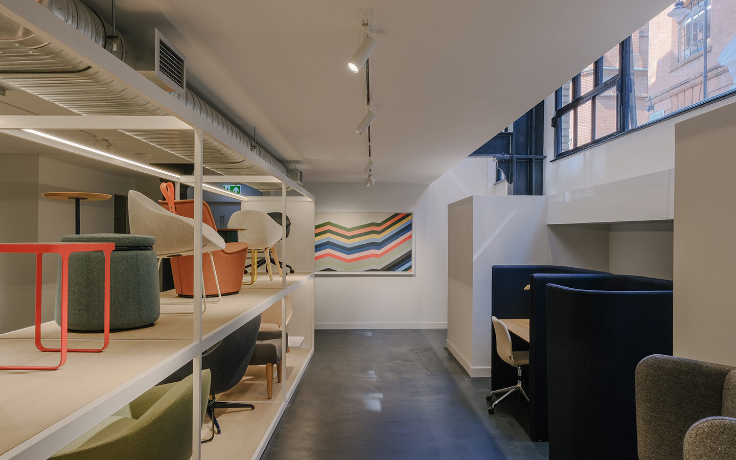 Modern office interior with colourful chairs and booths.