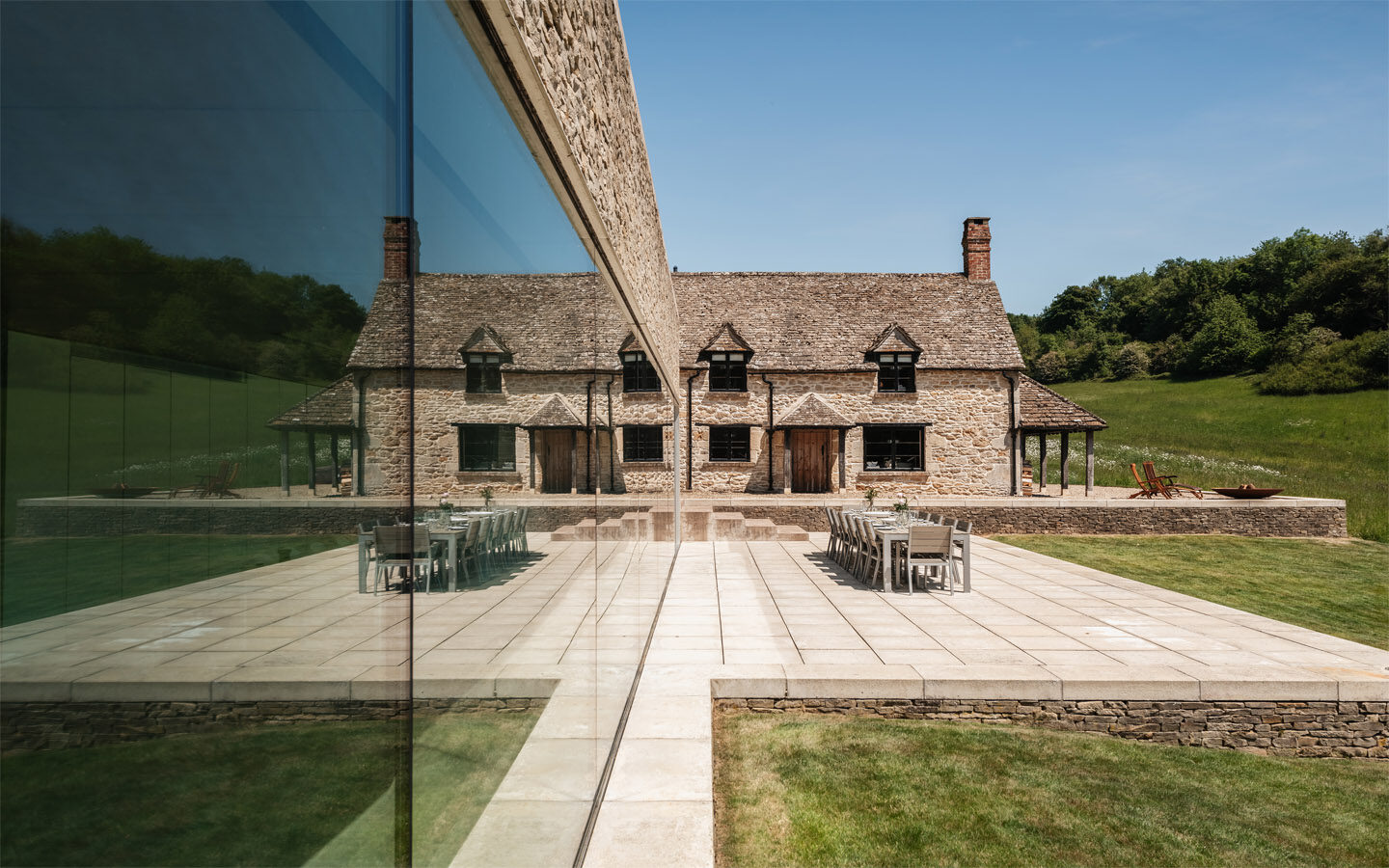 Stone house with mirrored modern extension.