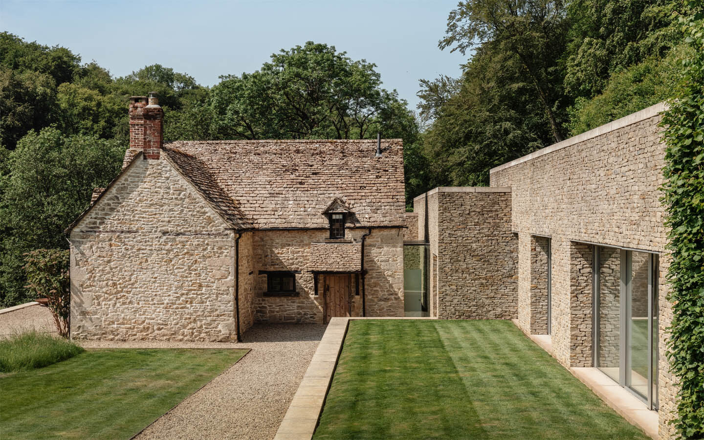 Rustic stone cottage with modern extension and garden.