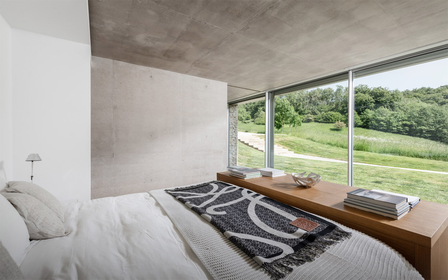 Modern bedroom with large window view of garden.
