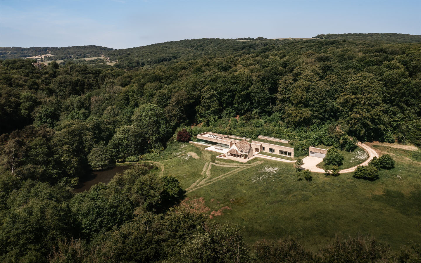 Aerial view of countryside house surrounded by forest.