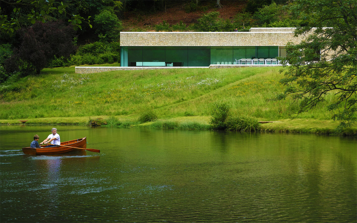 Modern house by lake with boat.