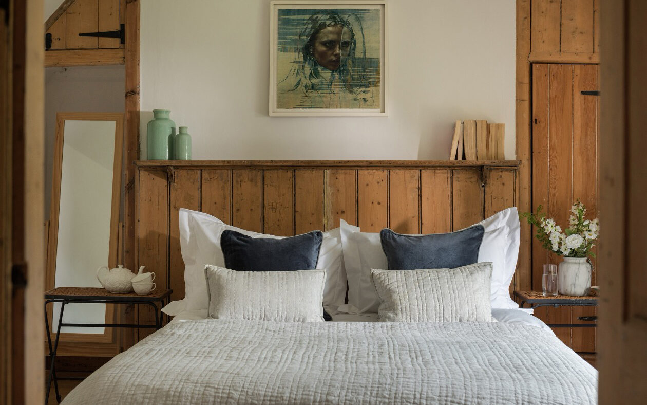 Cosy rustic bedroom with wooden decor and soft pillows.