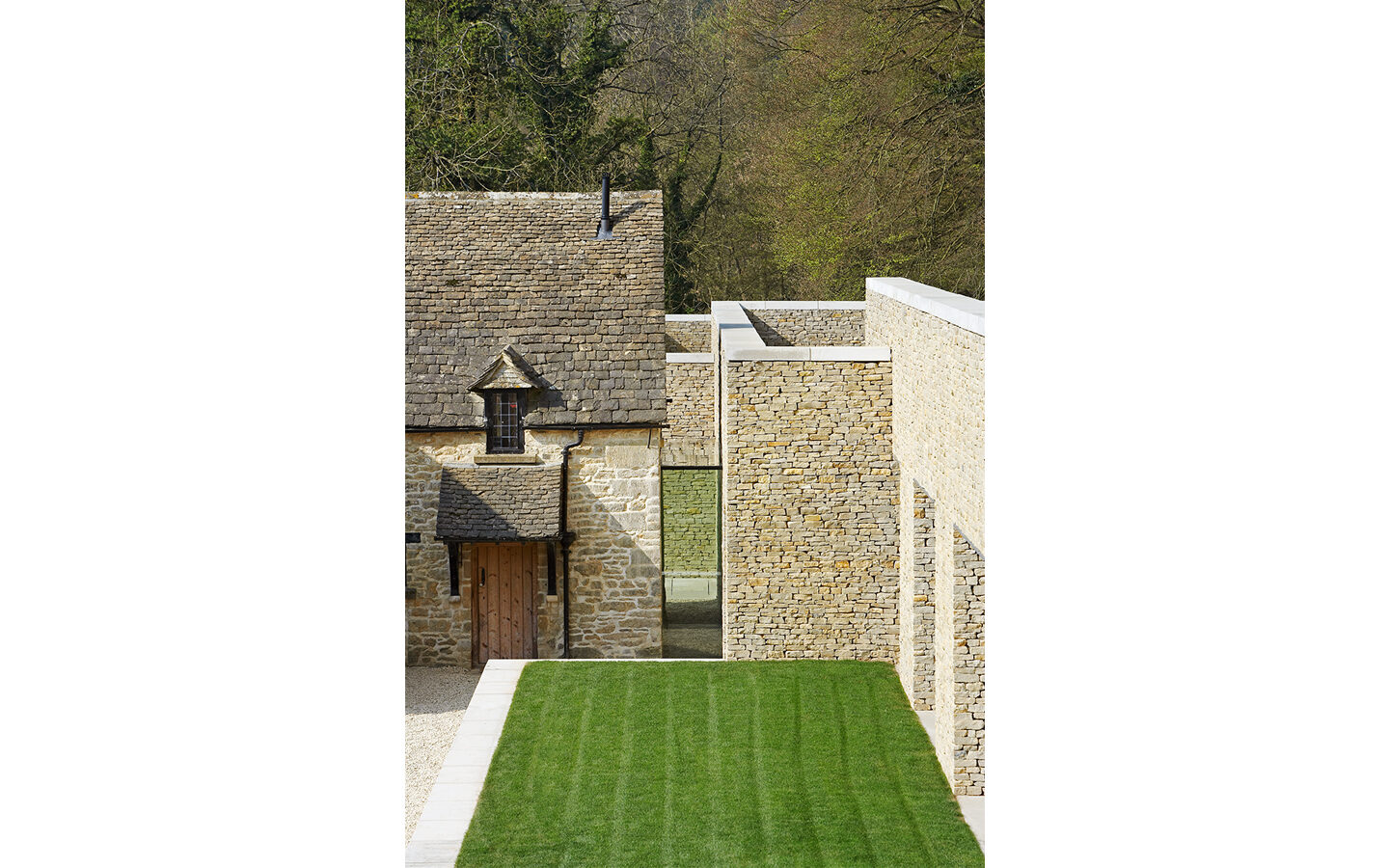 Stone building with grass lawn and trees.