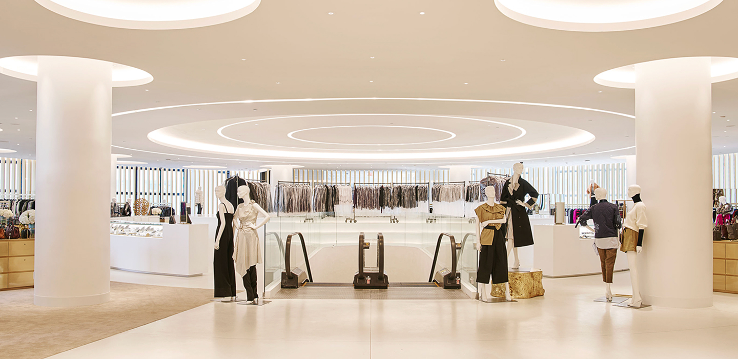 Modern department store interior with mannequins and escalator.