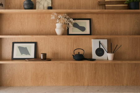 Wooden shelves with minimalist decor and framed art.