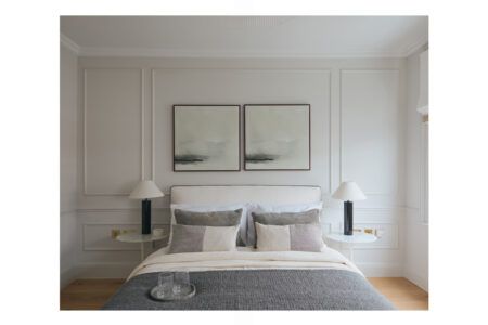 Modern bedroom with grey bedding and abstract art.