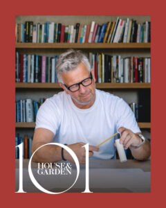 Man designing with pencil, books in background.